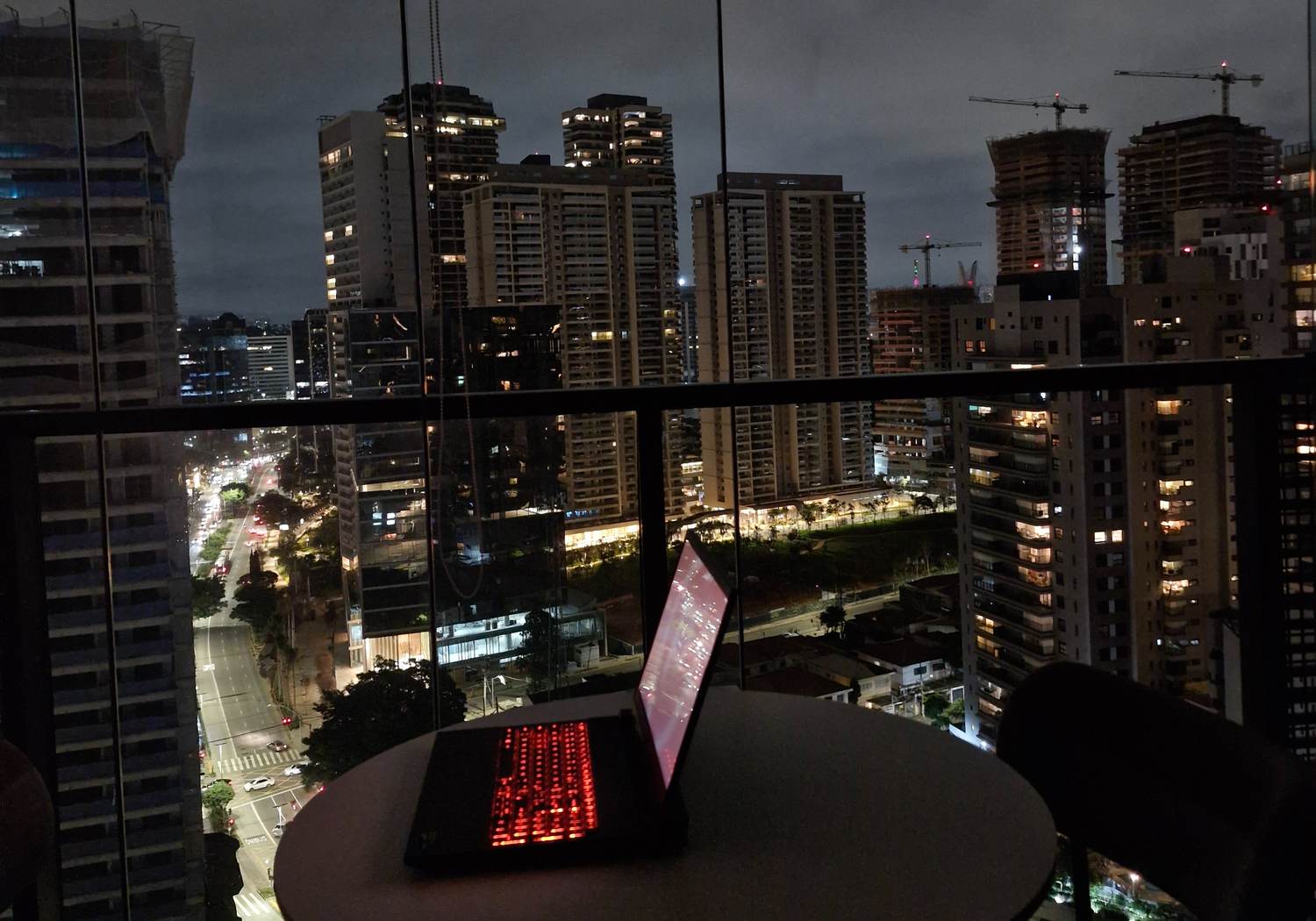Laptop with backlit keyboard overlooking the São Paulo skyline at night