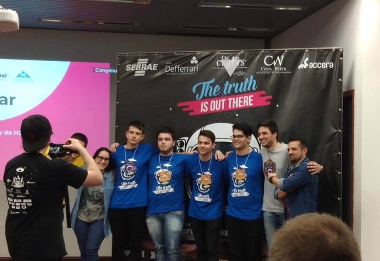 Gustavo com o time vencedor no palco do Startup Weekend